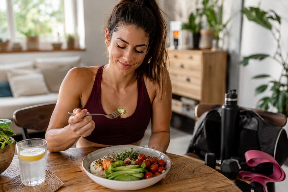 Mujer joven disfrutando de una comida saludable antes de entrenar