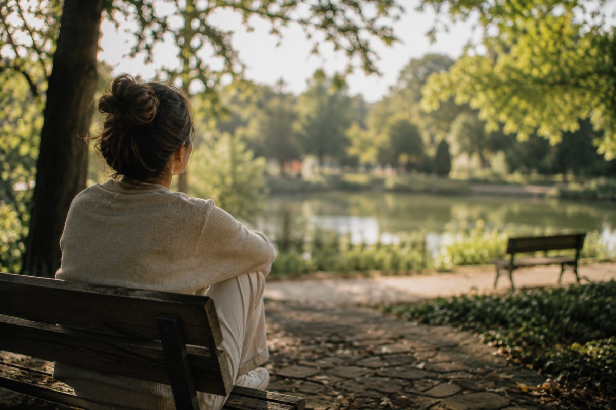 Una persona reflexionando en un parque tranquilo